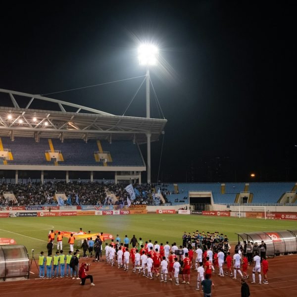 A group of people standing on top of a soccer field